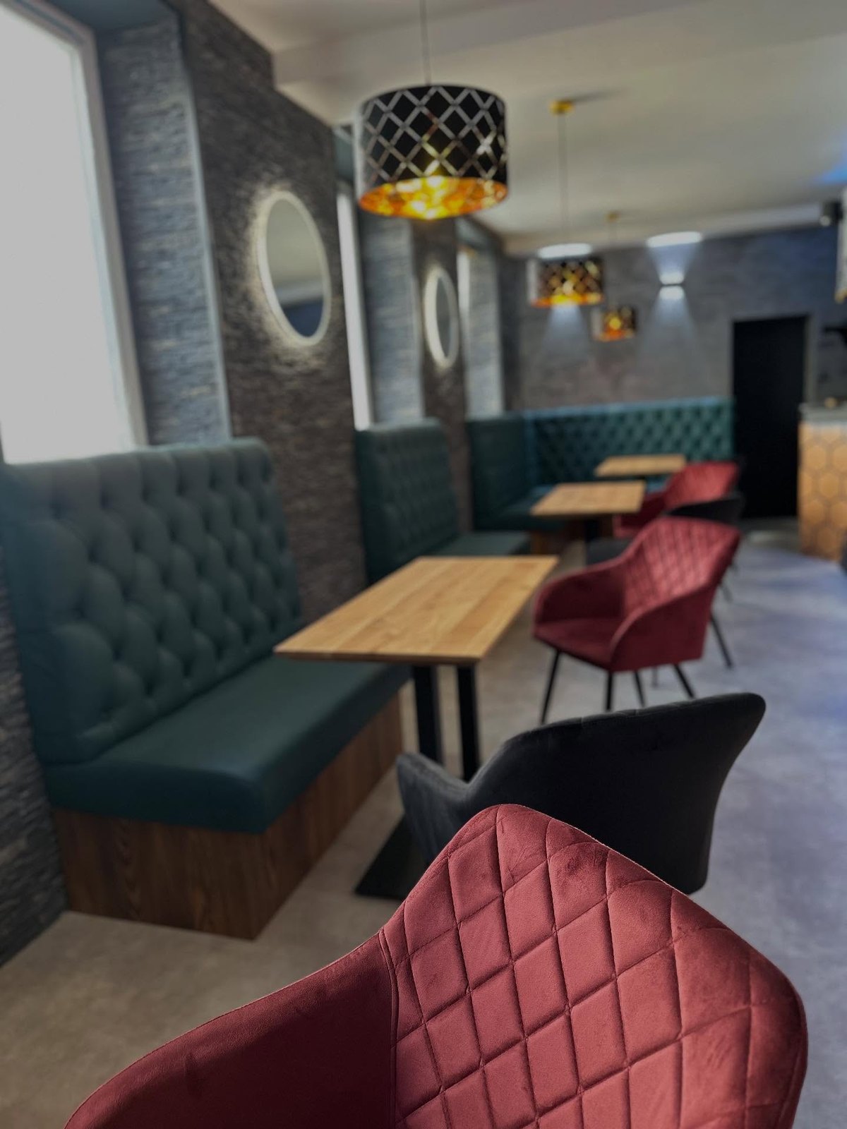 Gastraum im Parlament Caffé mit grünen Chesterfield-Bänken